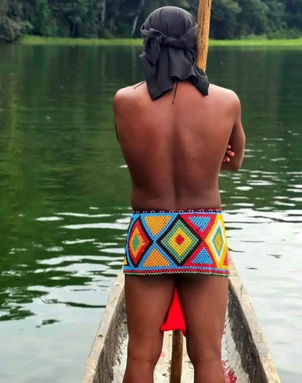 Emberá paddler in a dugout canoe on the river